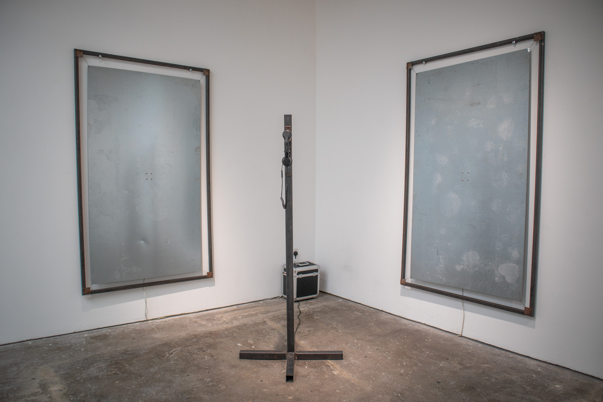 Phone on a metal pole with a red light ontop of it